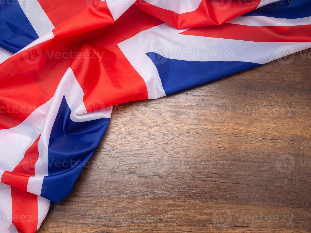 Top view of the United Kingdom flag on a wooden table with space for text. Close-up photo