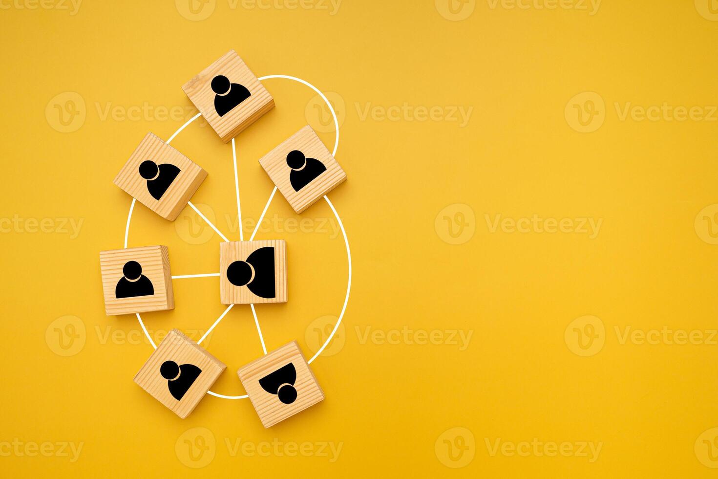 Top view of wooden blocks with black human icons scattered on a yellow background. photo