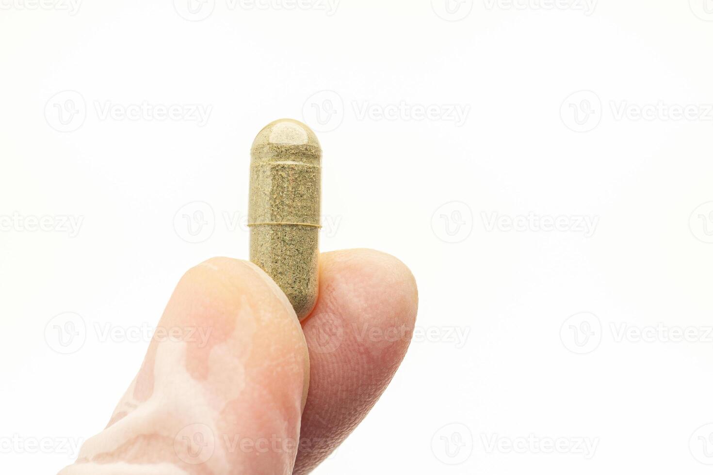 Hand holding of Andrographis paniculata capsule isolated on white background. Herbal, medicine, and healthcare concept photo