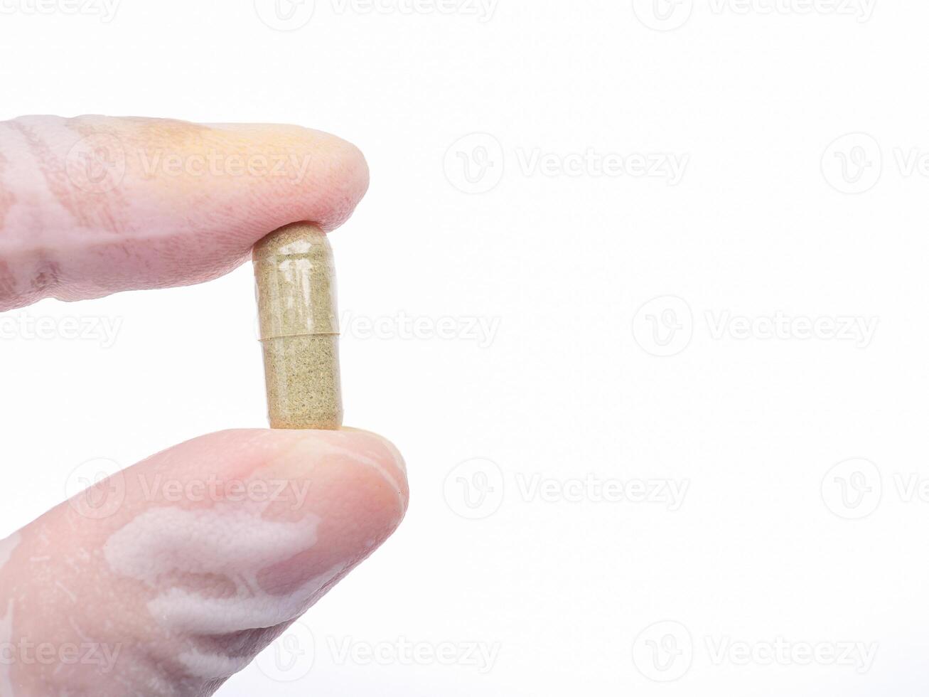 Hand holding of Andrographis paniculata capsule isolated on white background. Herbal, medicine, and healthcare concep photo