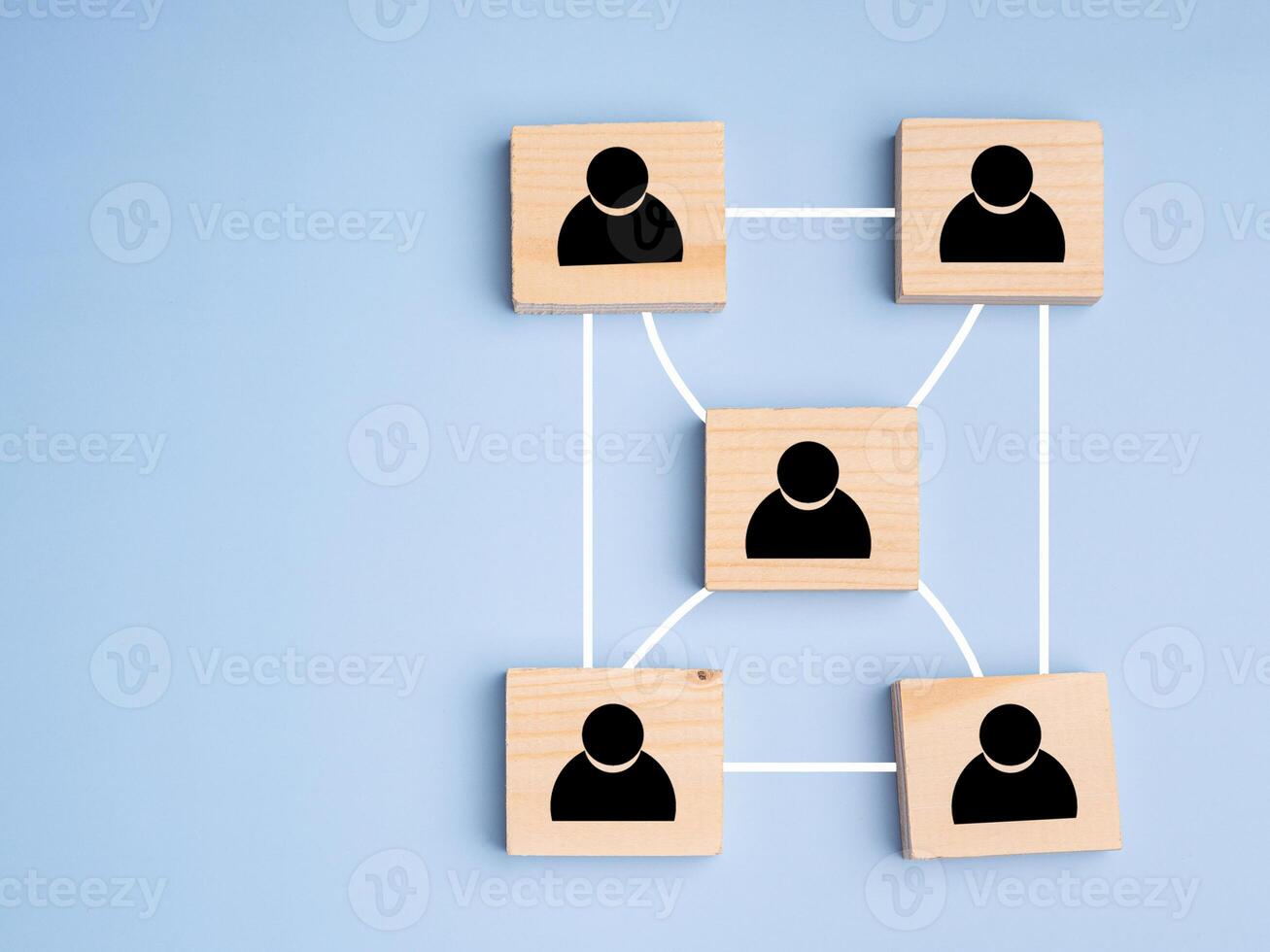 Top view of wooden blocks with black human icons scattered on a light blue background. photo