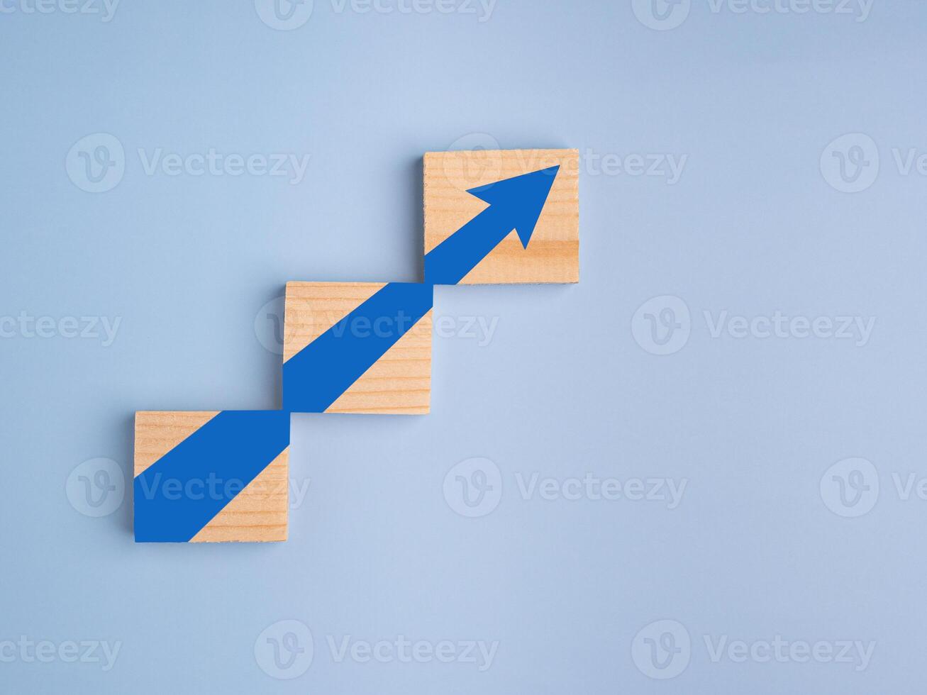 Wood blocks with arrows up. Business growth or increasing concept picture, the rising arrow on wooden blocks laid on a light blue background. Business and strategy concept photo
