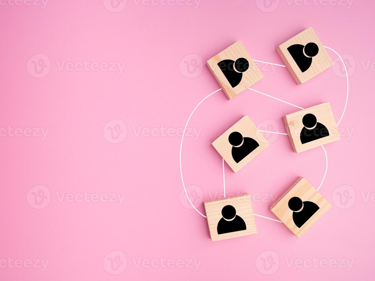 Top view of wooden blocks with black human icons scattered on a light blue background photo