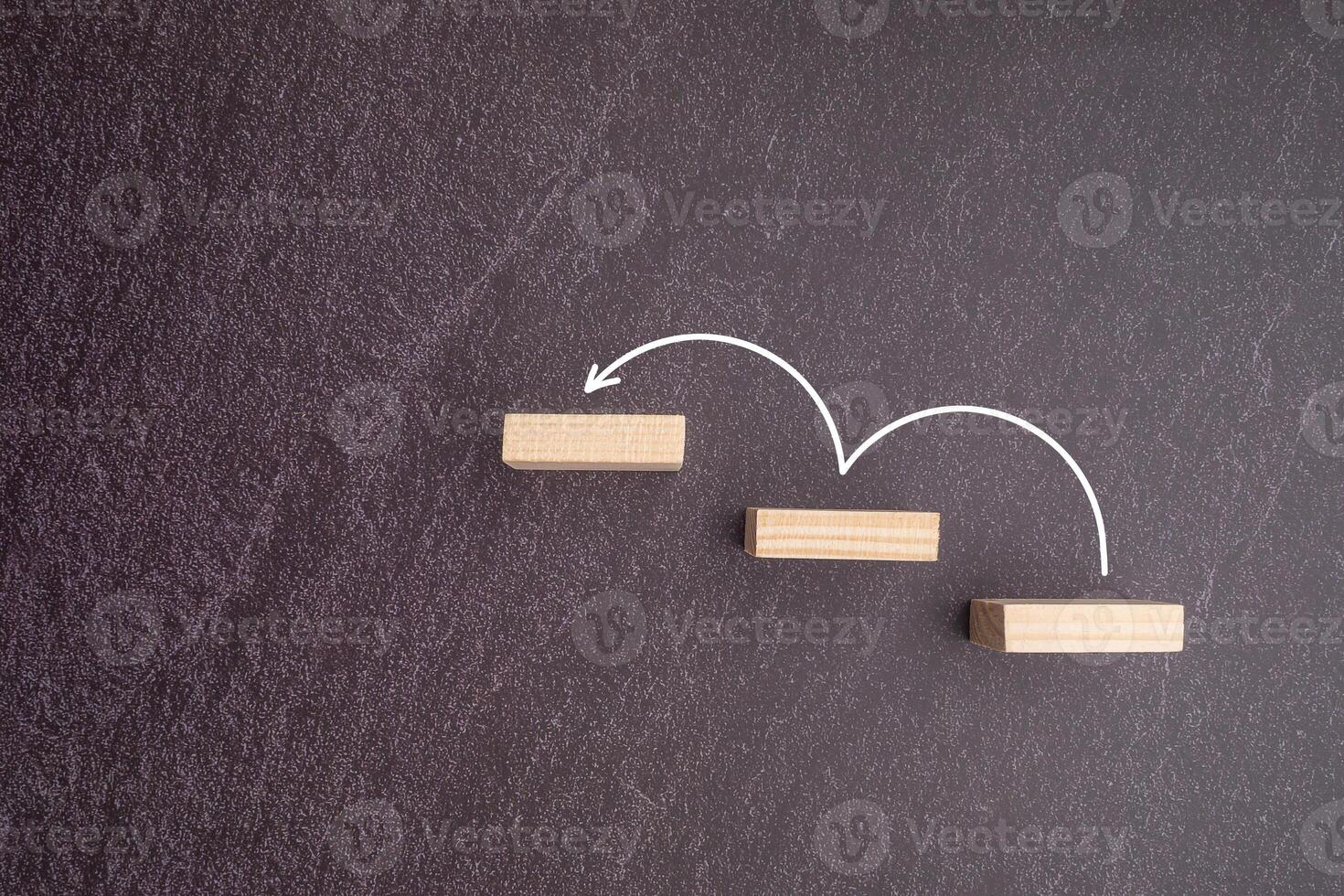 Business growth or increasing concept picture, the rising arrow on wooden blocks the staircase isolated on a gray stone background photo