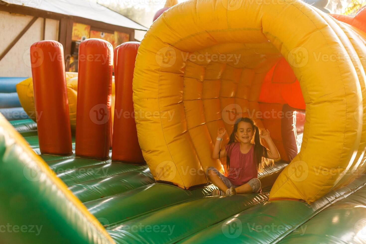 A cheerful child plays in an inflatable castle photo