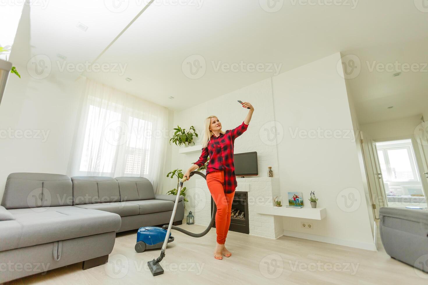 Young woman using vacuum cleaner at home photo
