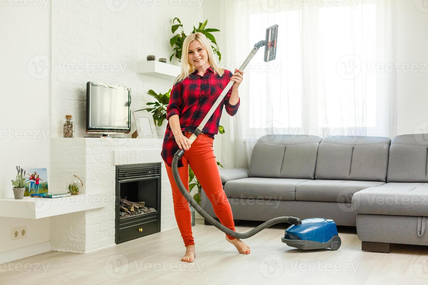 Young woman using vacuum cleaner at home. photo