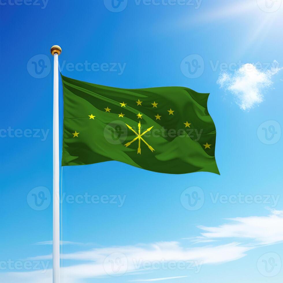 Waving flag of Adygea is a region of Russia on flagpole photo