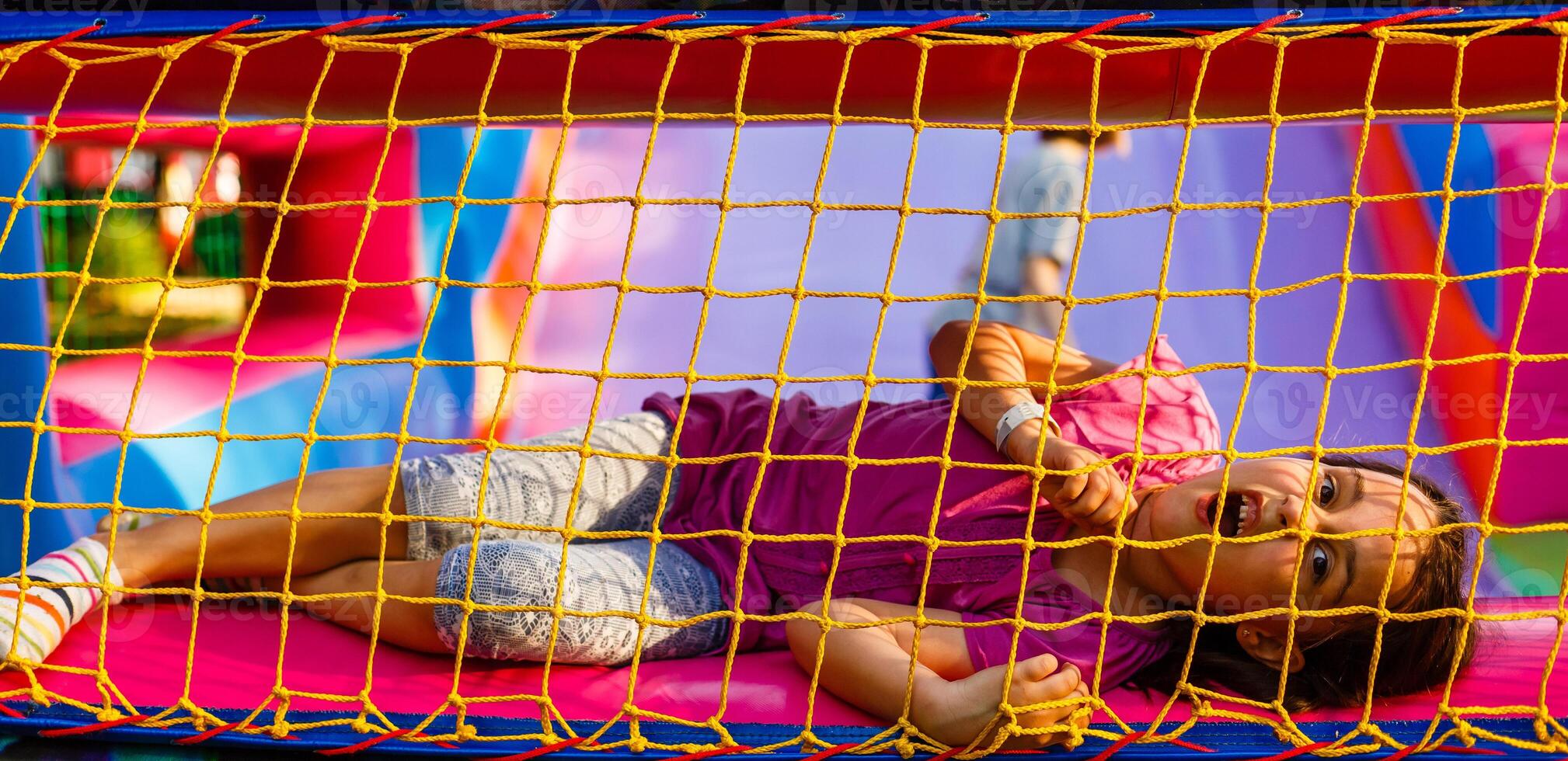 A cheerful child plays in an inflatable castle photo