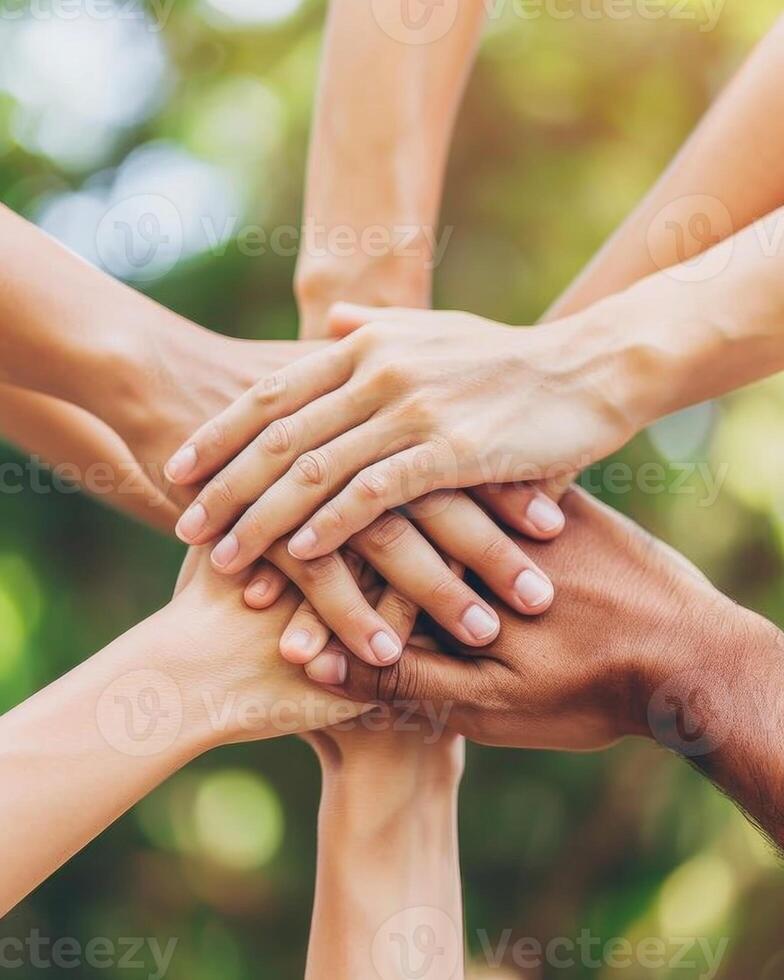 Team of businesspeople stacking hands showing unity and teamwork photo