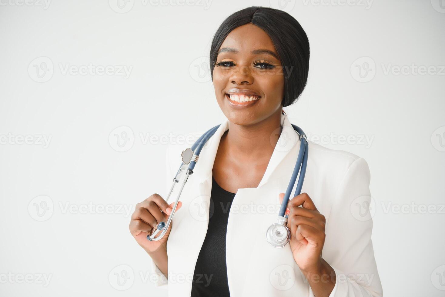 Portrait of beautiful smiling female african american doctor standing in medical office. Health care concept, medical insurance, copy space. photo