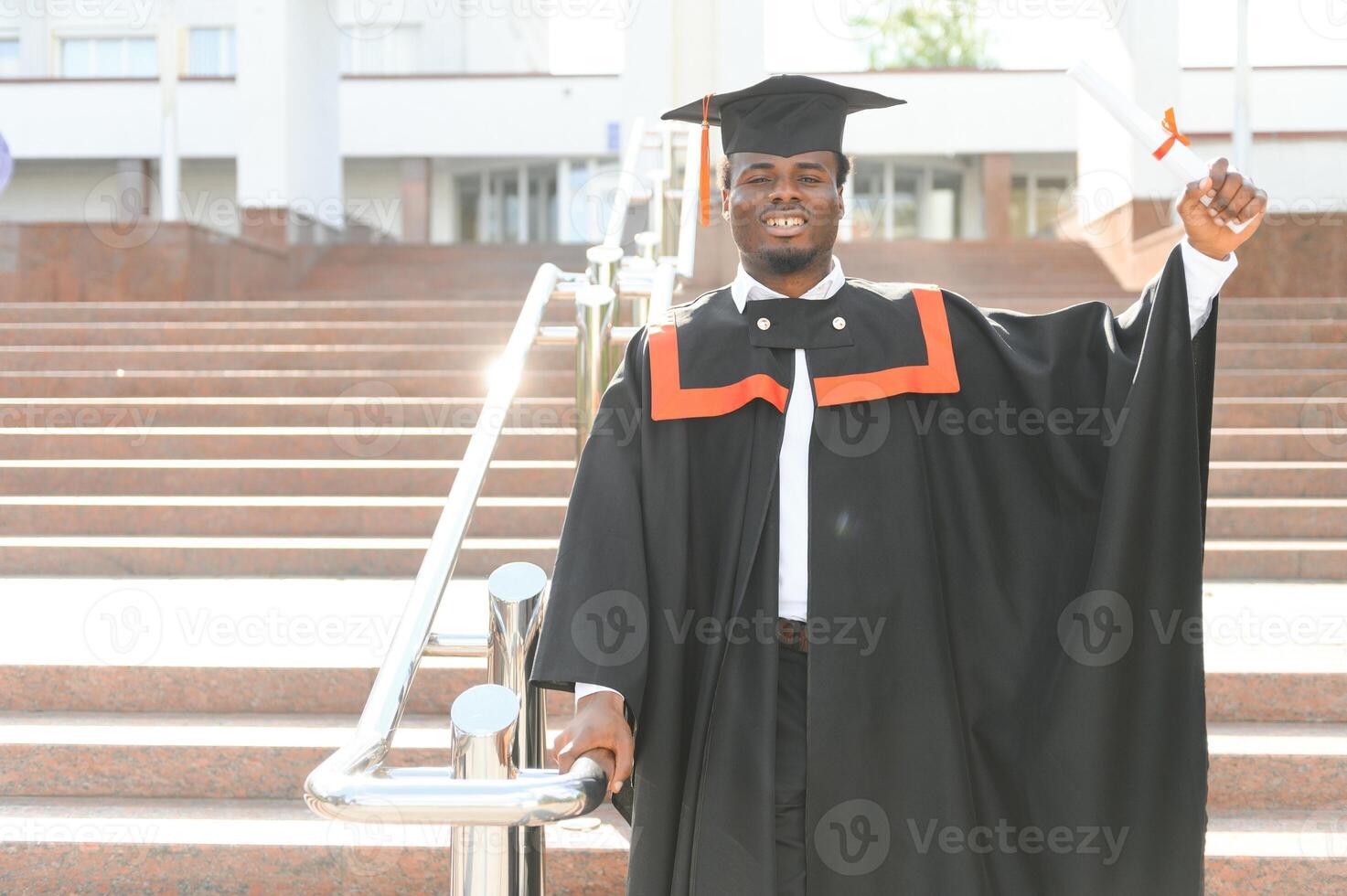 smiling african american graduated student showing diploma photo