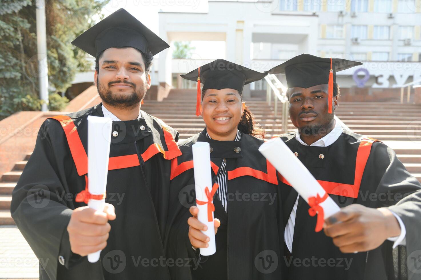 Diverse international students with diplomas at university campus photo