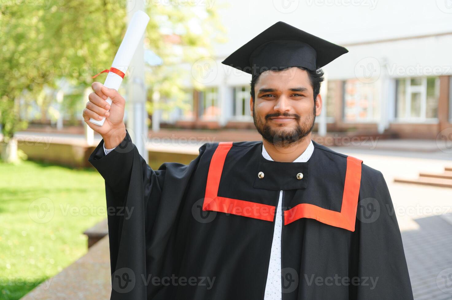 Portrait of happy man, graduation or student in university campus photo