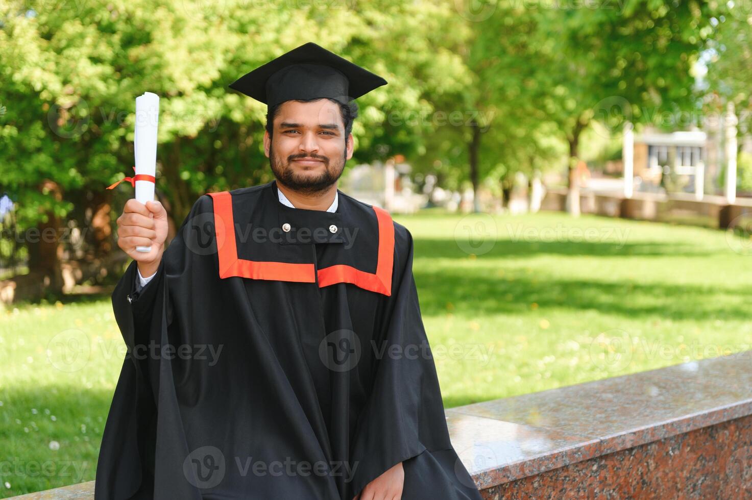 Portrait of happy man, graduation or student in university campus photo