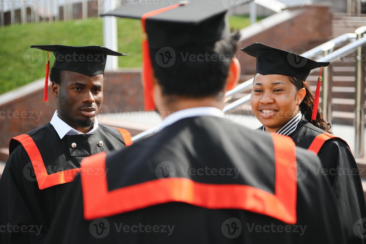 education, graduation and people concept - group of happy international students in mortar boards and bachelor gowns with diplomas photo