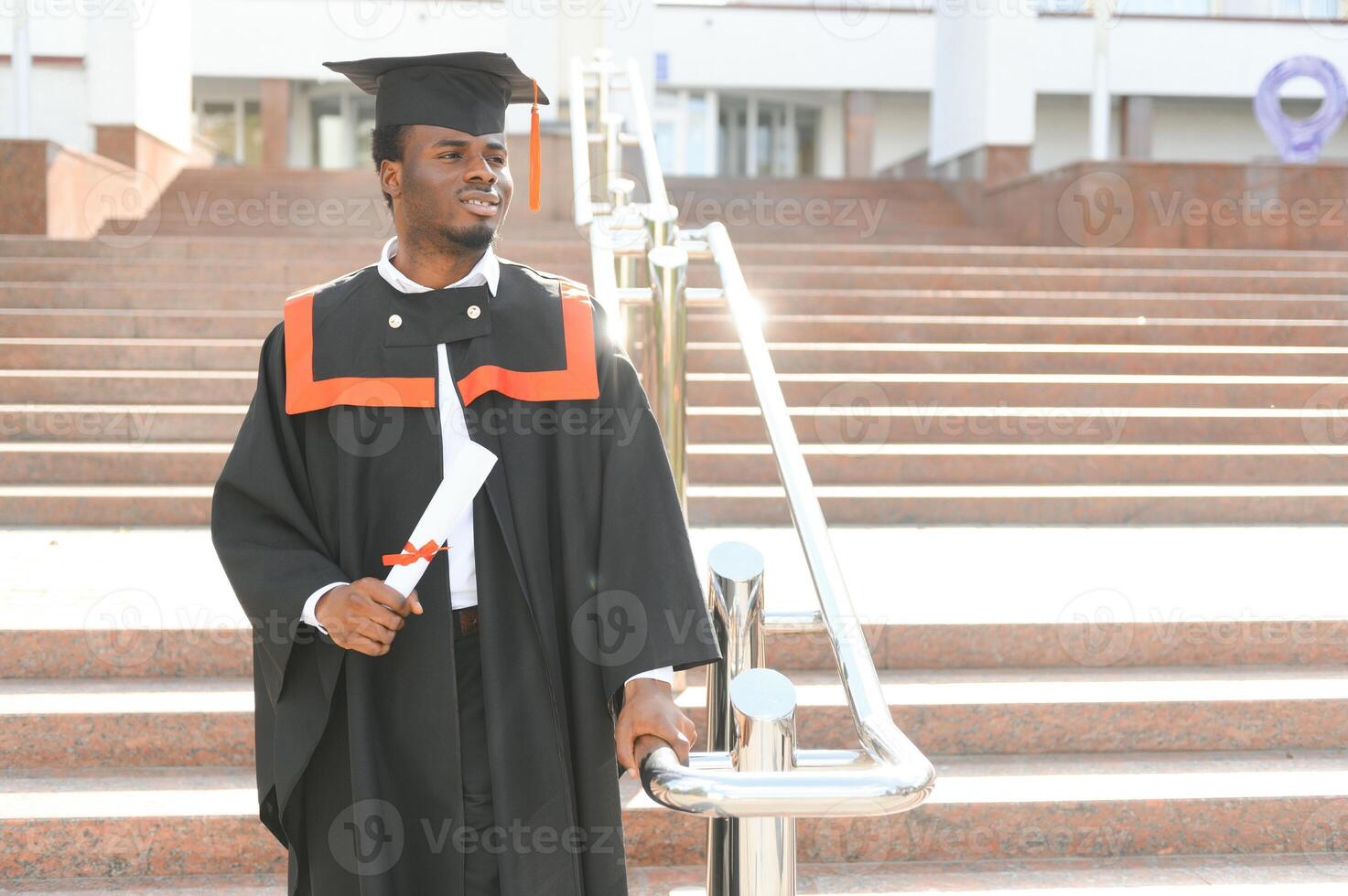 Happy graduate. Happy African man in graduation gowns photo