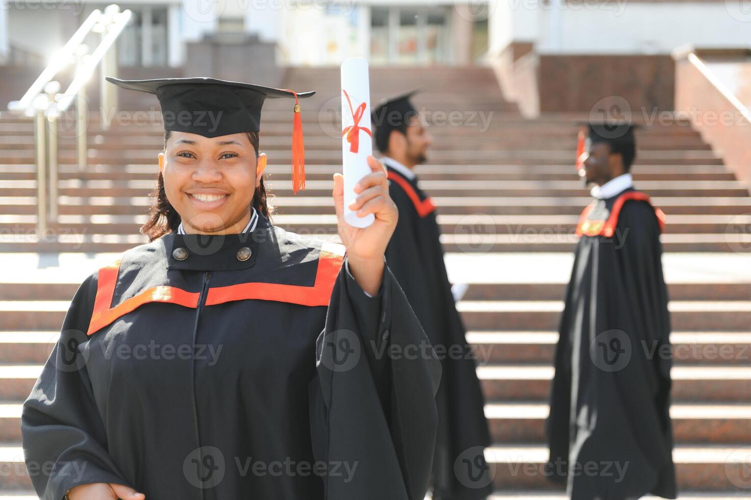 pretty african female college graduate at graduation with classmates photo