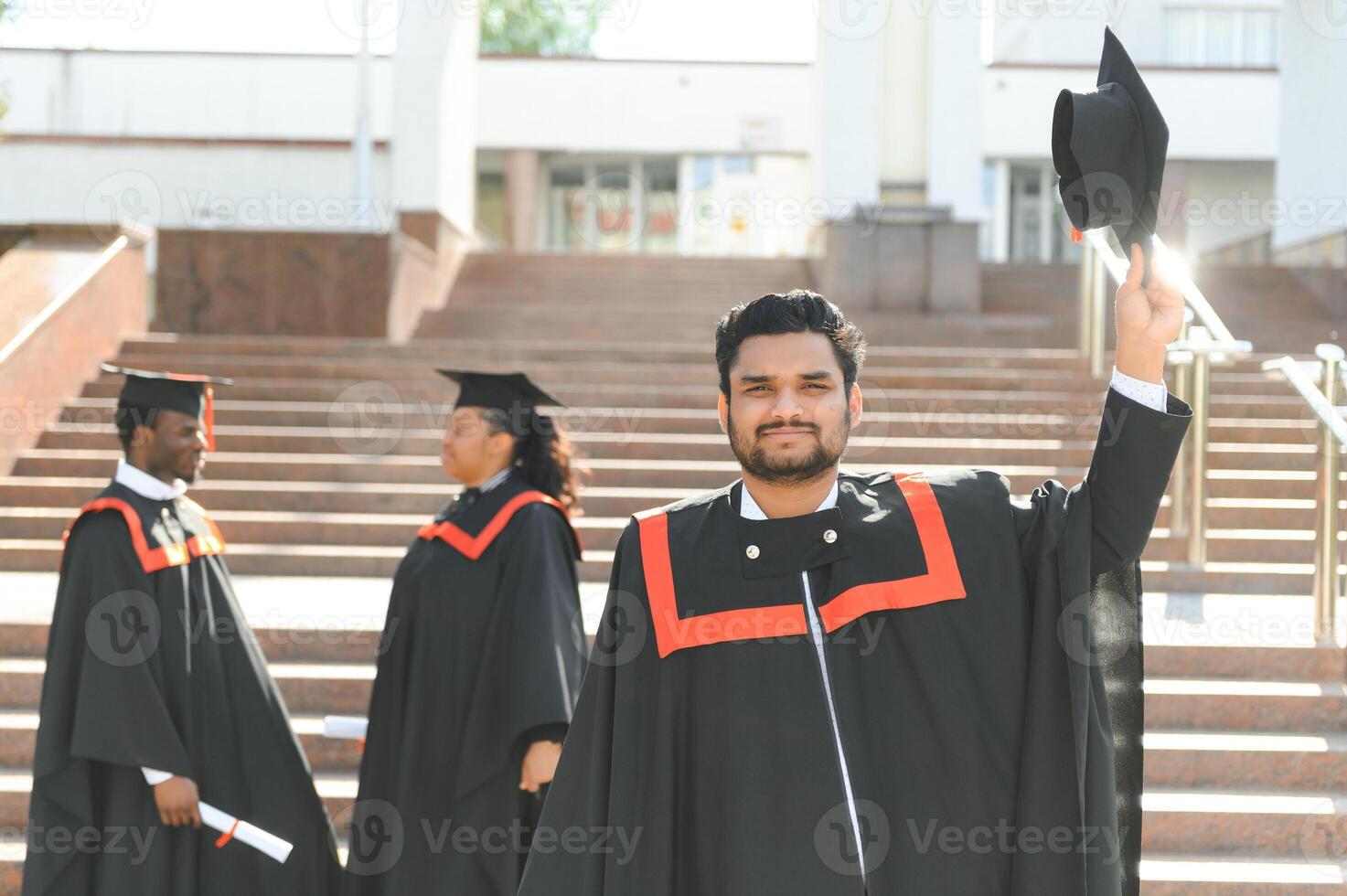 Handsome indian graduate in graduation glow with diploma photo