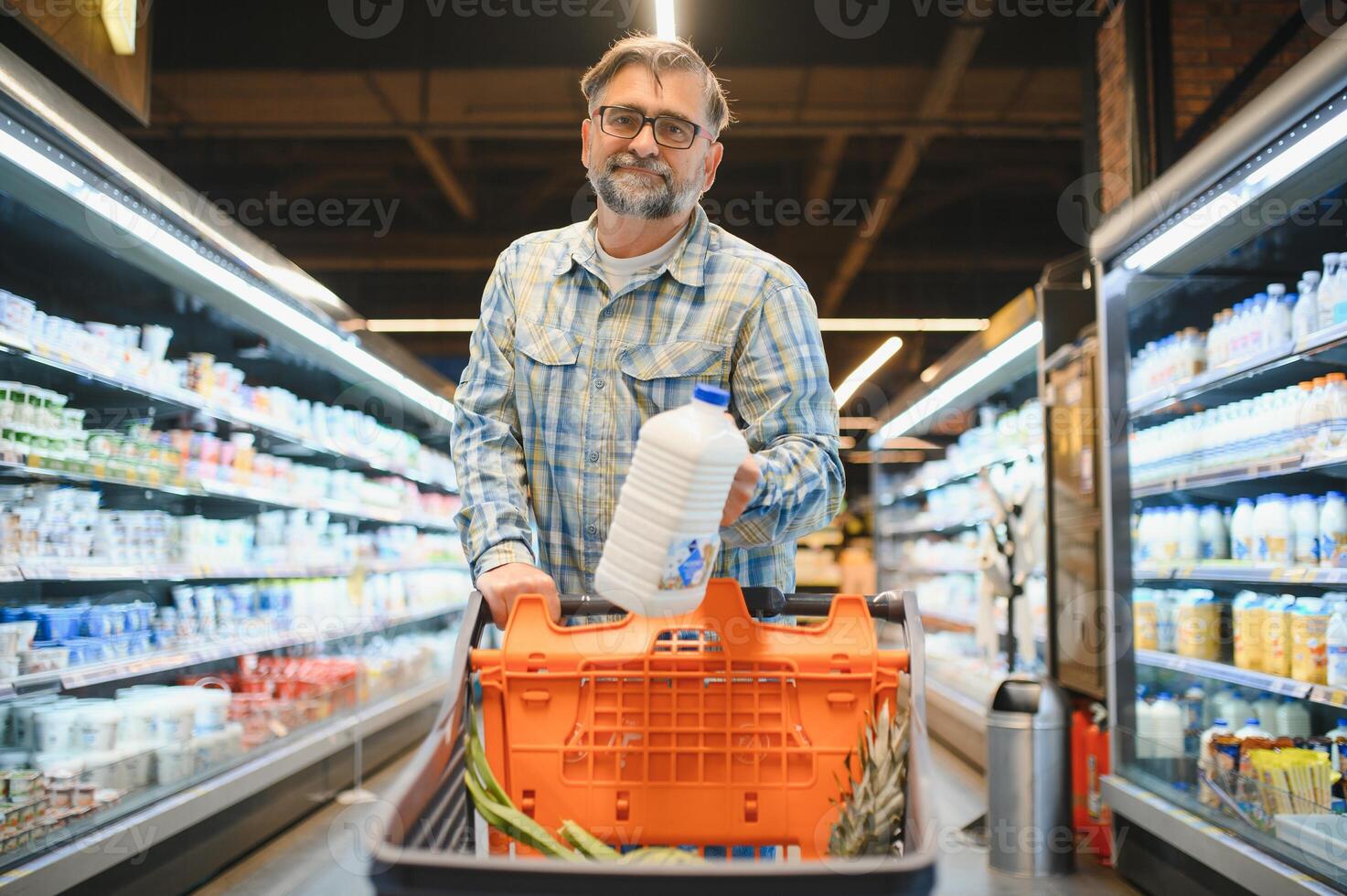 Old man choosing products on grocery shopping buying food in supermarket photo