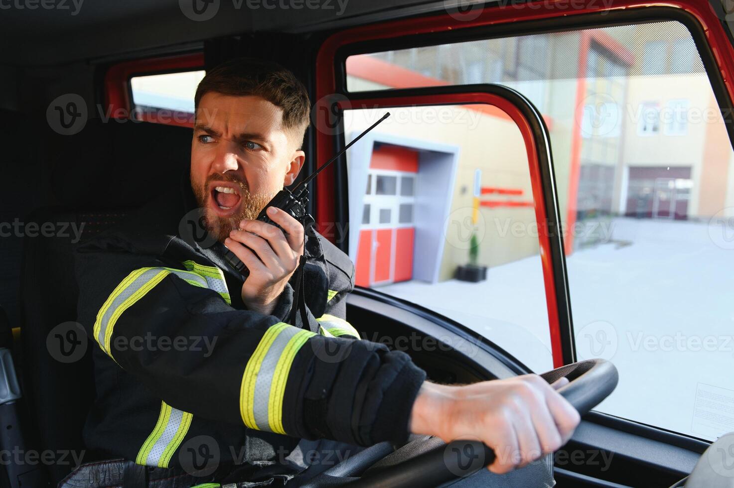 Firefighter using radio set while driving fire truck photo