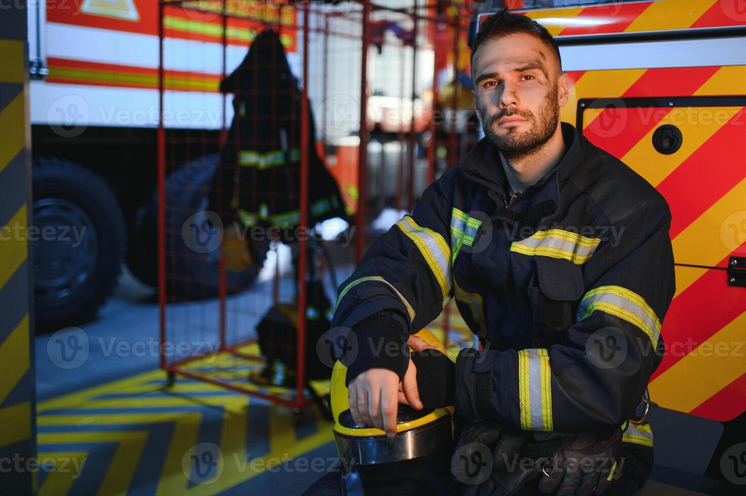 Portrait of a firefighter in a protective suit and a protective helmet standing by a fire engine after working on a fire. Close-up image photo