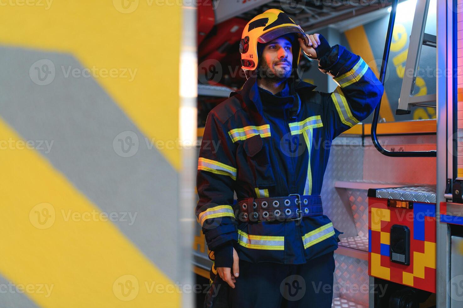 Portrait of male firefighter in uniform at fire station photo