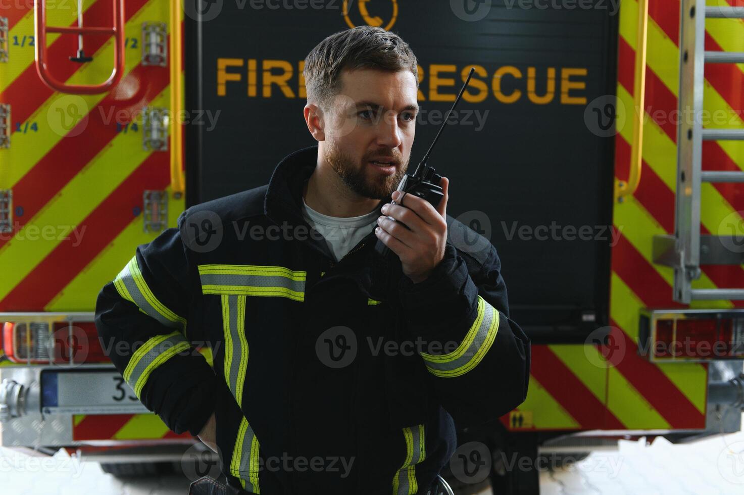 Firefighters man in a protective suit near fire truck. Protection, rescue from danger. Fire station photo