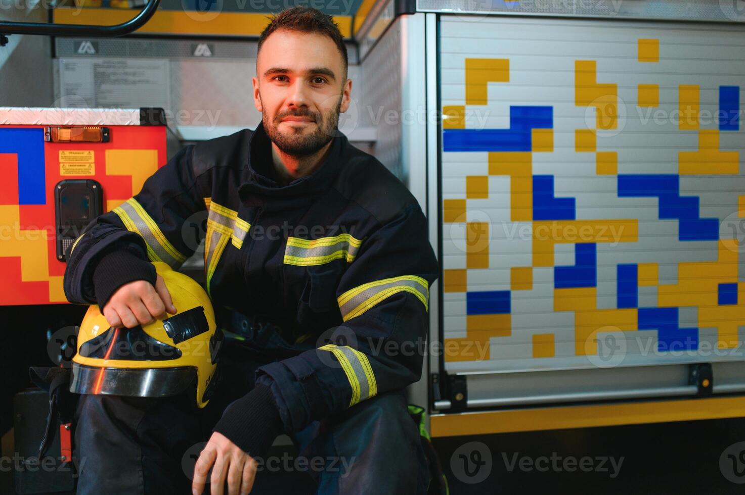 Portrait of male firefighter in uniform at fire station photo