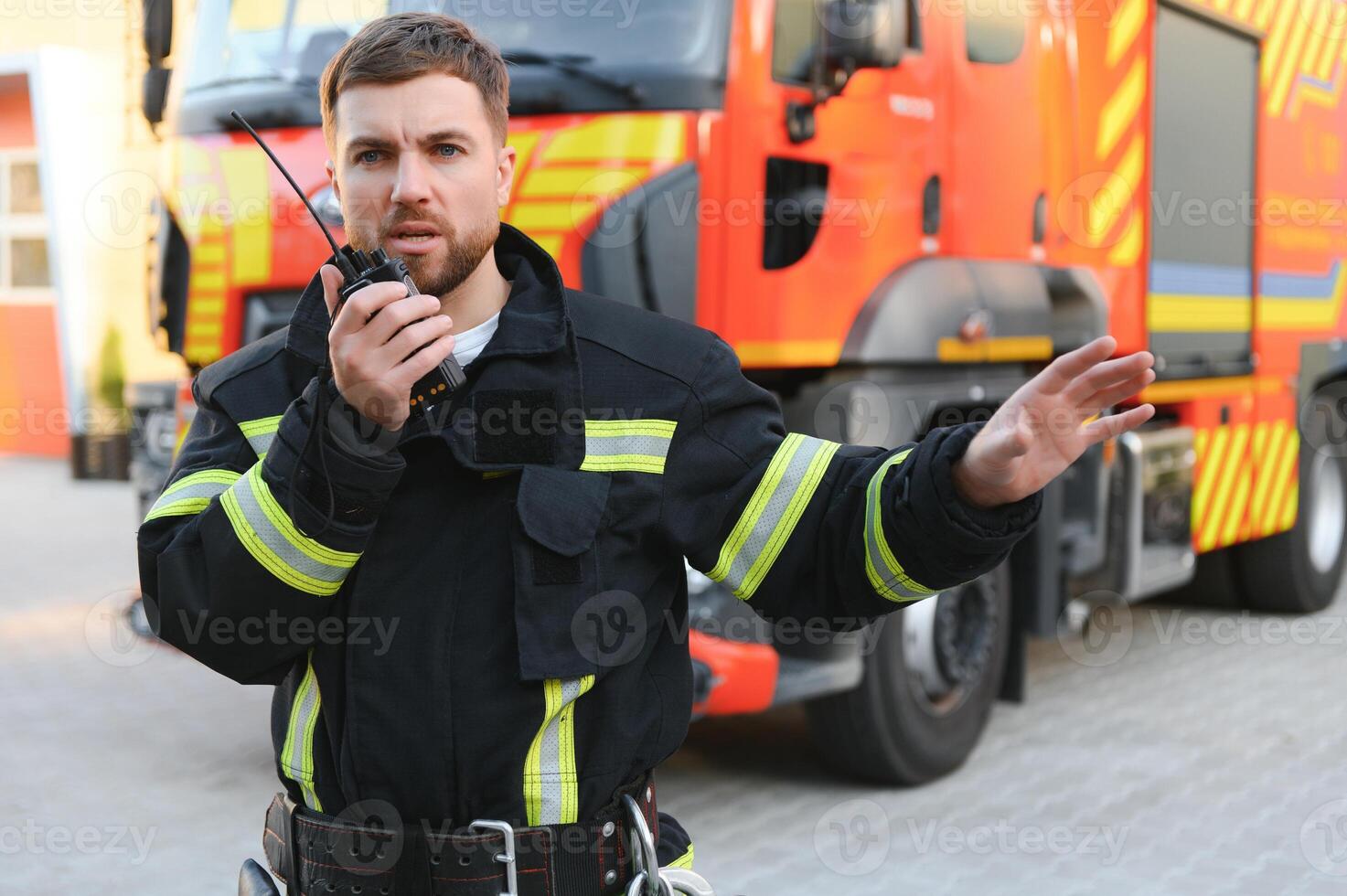 Firefighters man in a protective suit near fire truck. Protection, rescue from danger. Fire station photo