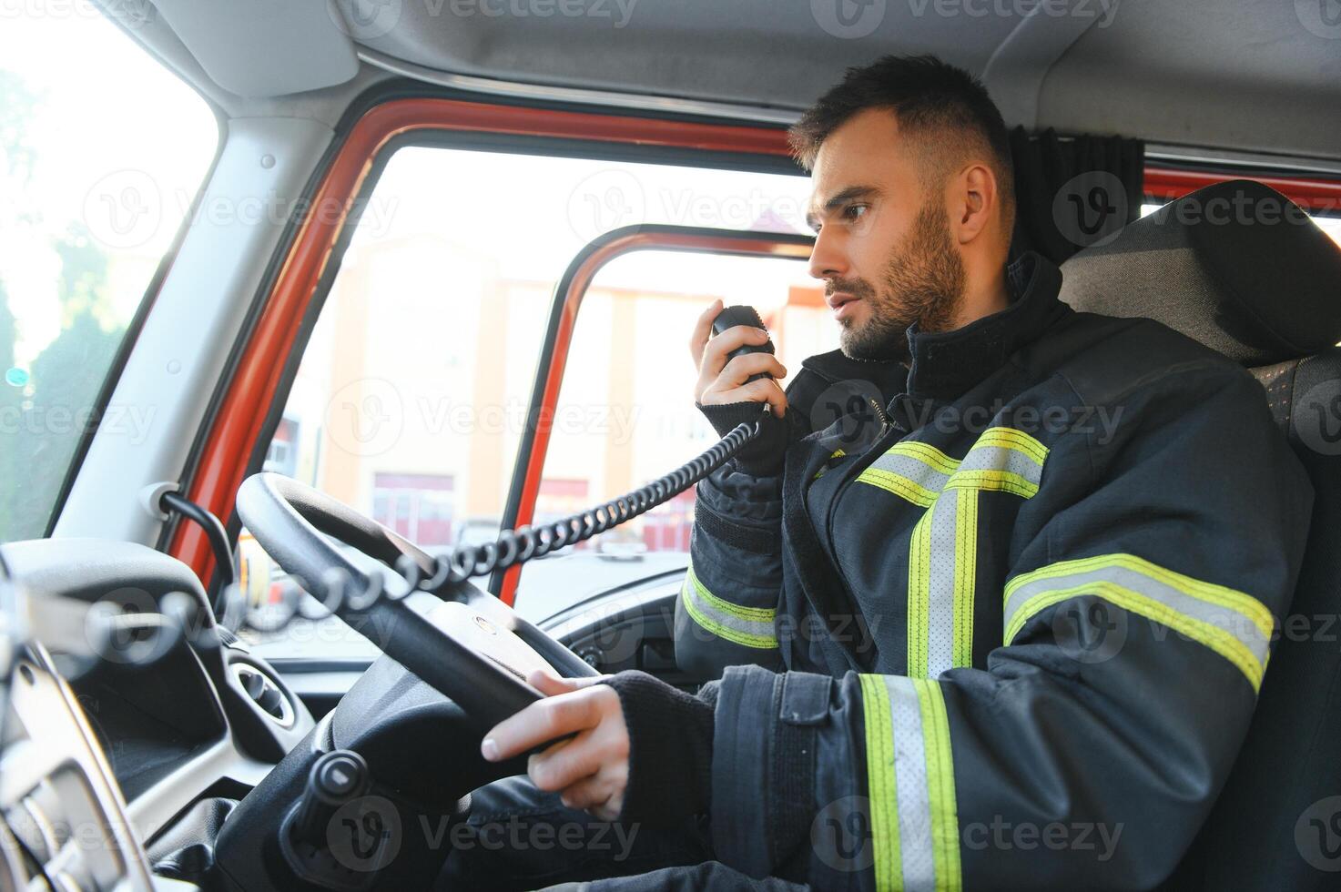 Firefighter drives a emergency vehicle with communication interior view photo