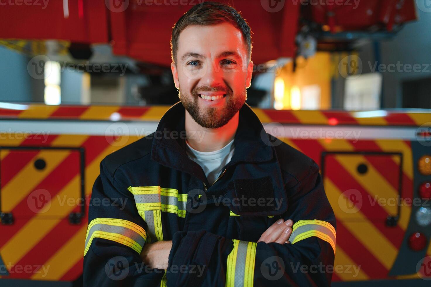 Firefighter in uniform and helmet near fire engine photo