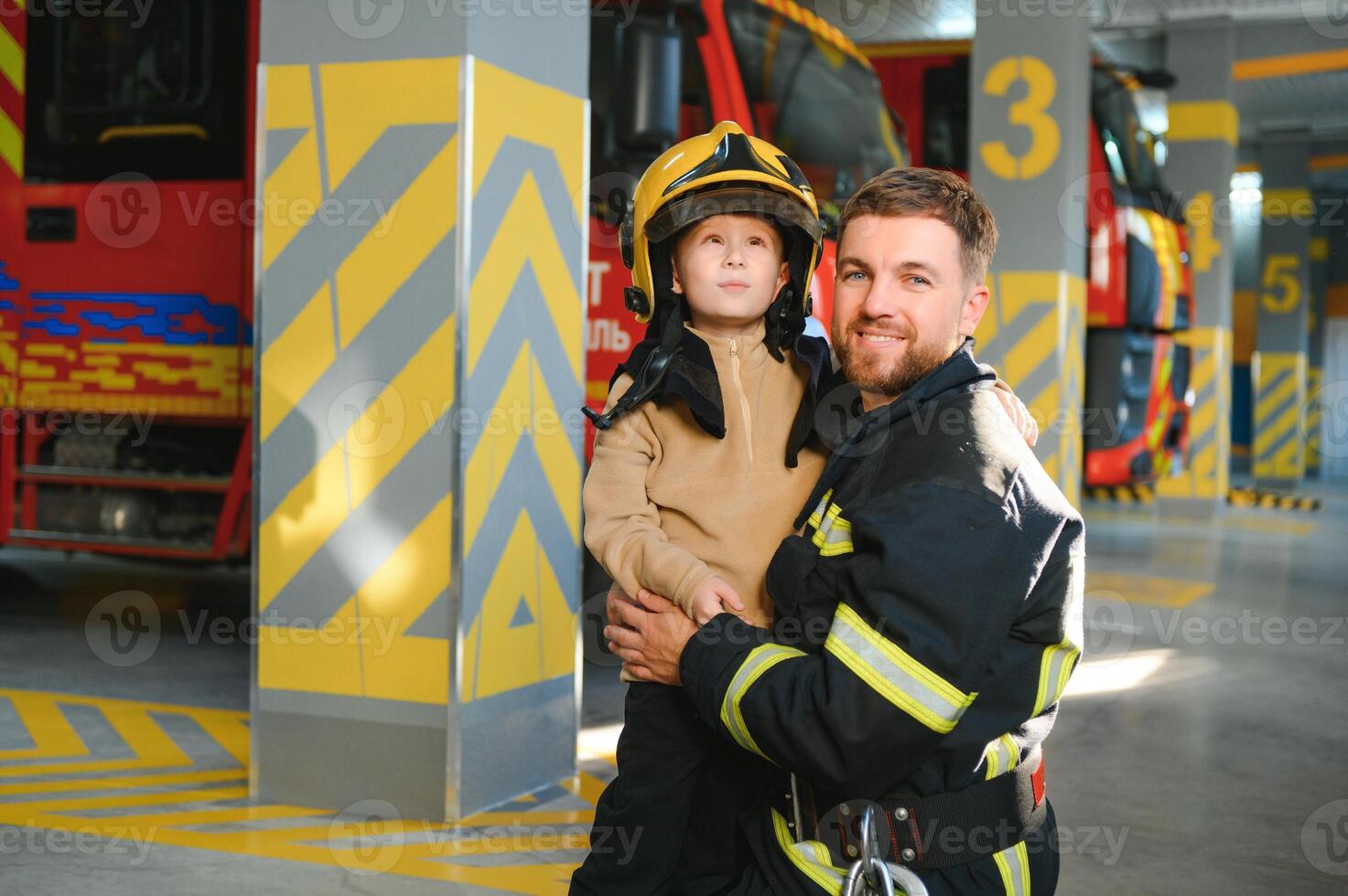 A firefighter take a little child boy to save him. Fire engine car on background photo