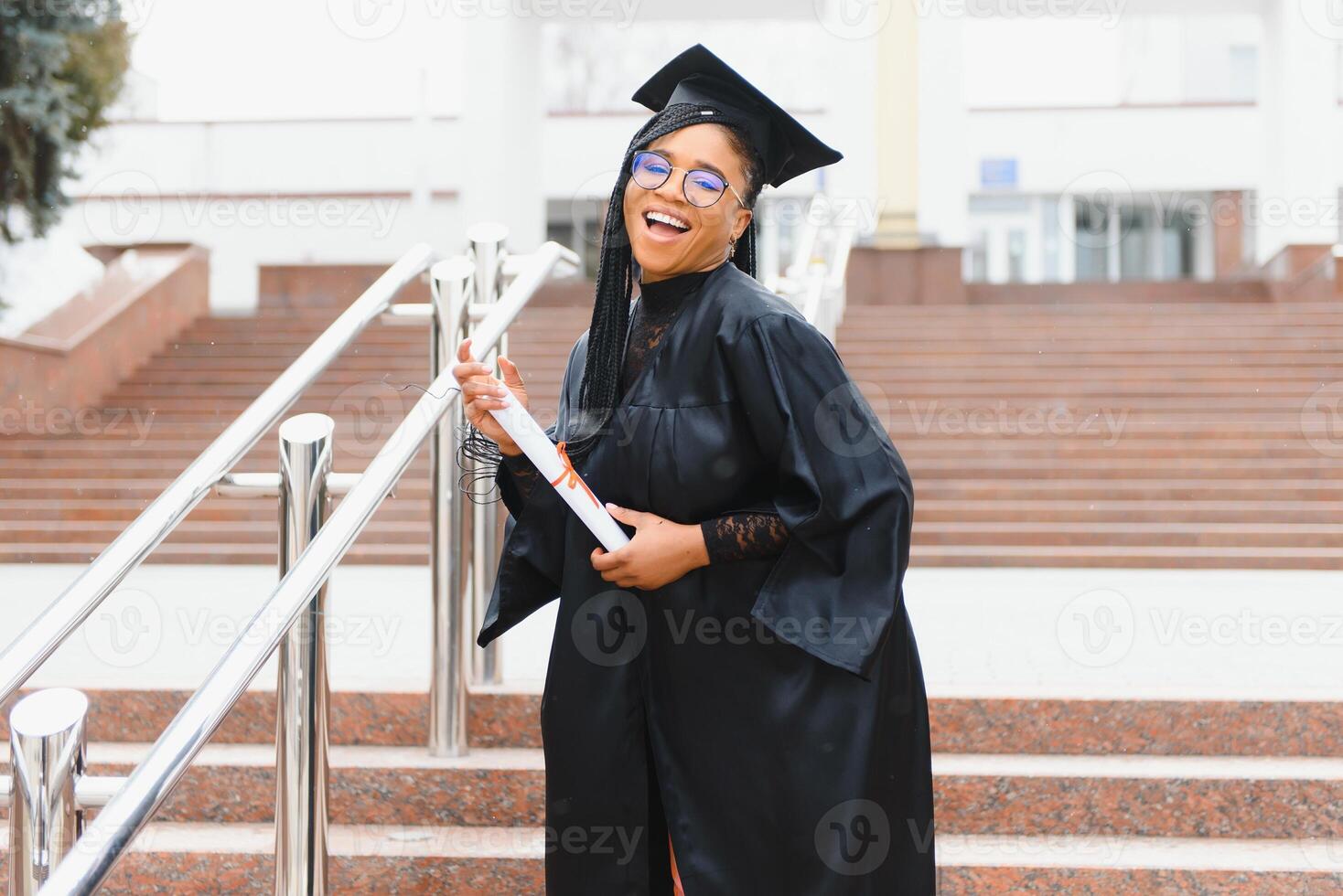 happy african american female student with diploma at graduation photo
