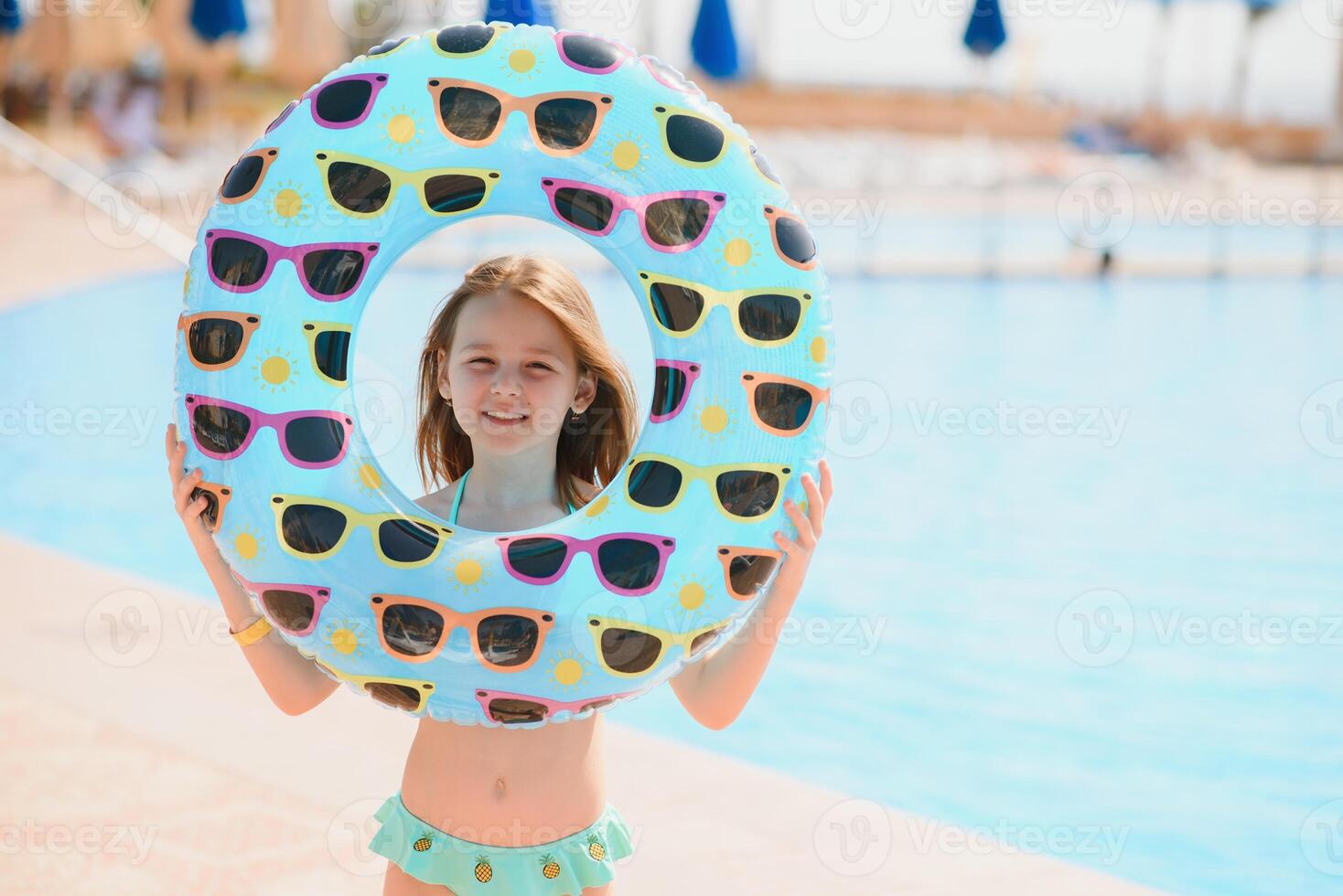 The concept of recreation at sea. The girl holds an inflatable circle for swimming by the pool photo