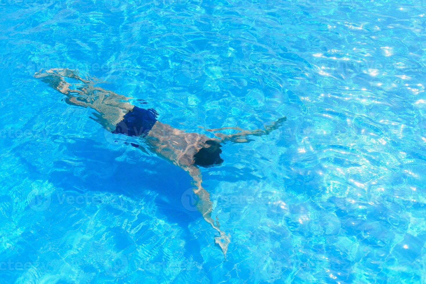 Young athletic man swimming in the swimming pool. Active sport photo