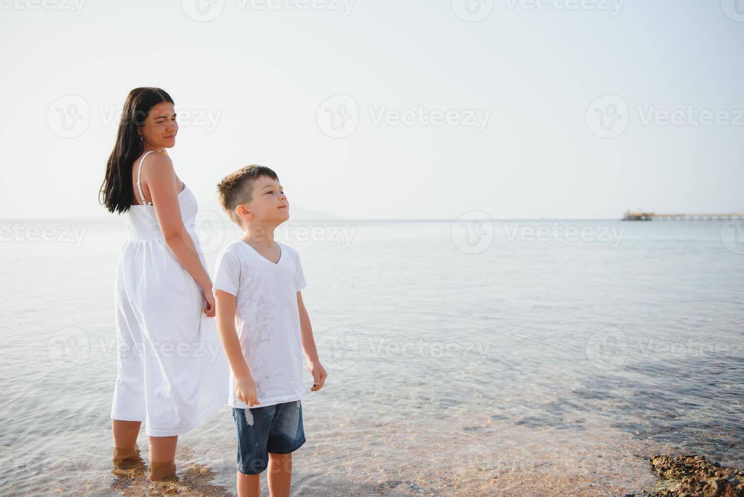 happy mother with son walk on beach, family at sea photo