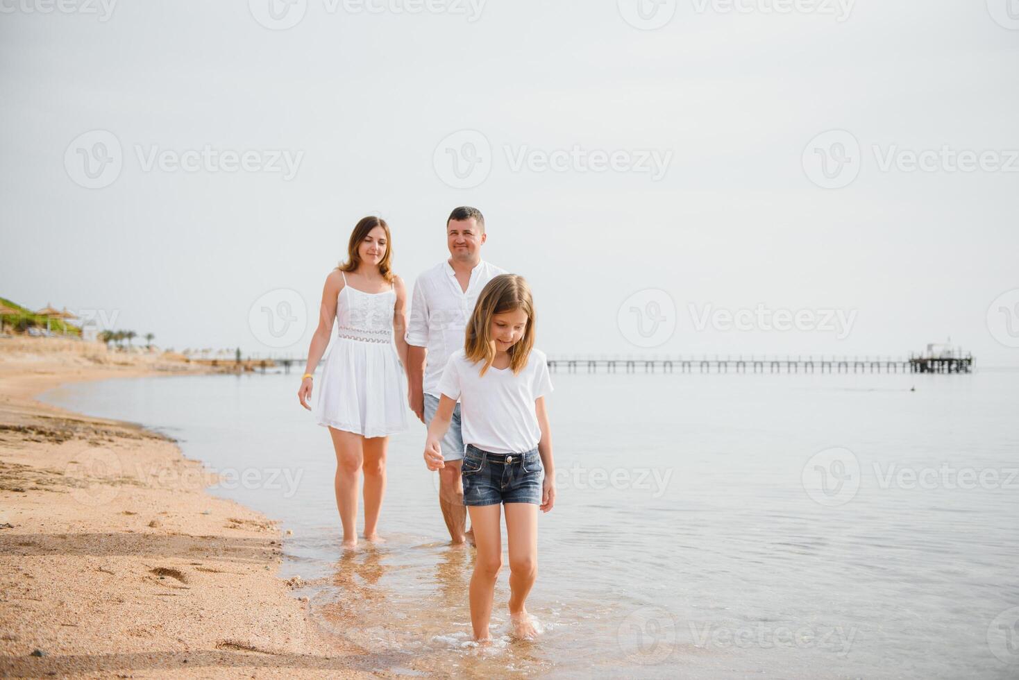 Happy family walking on the beach photo