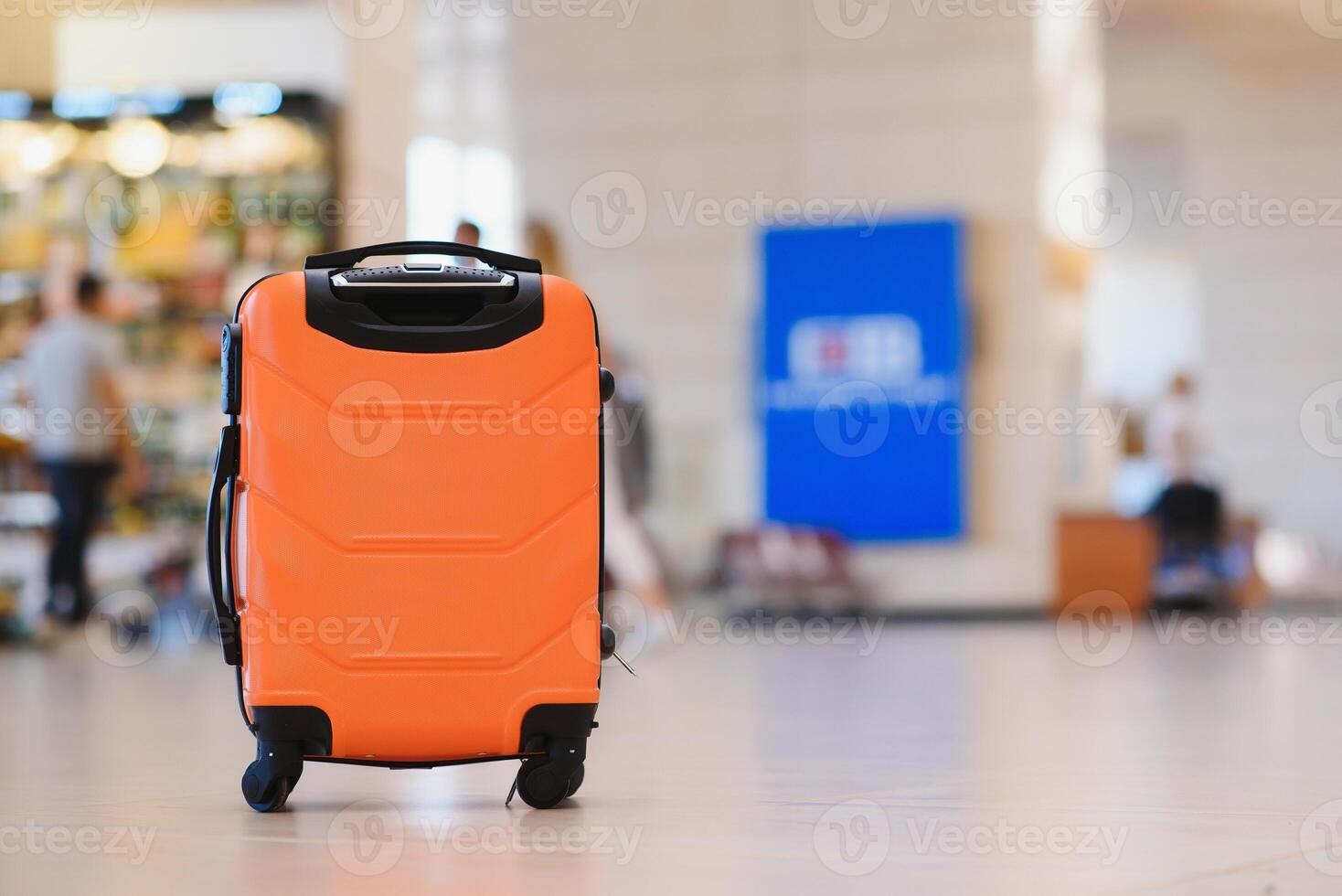 Large suitcase standing on the floor in modern airport terminal. Copy space photo