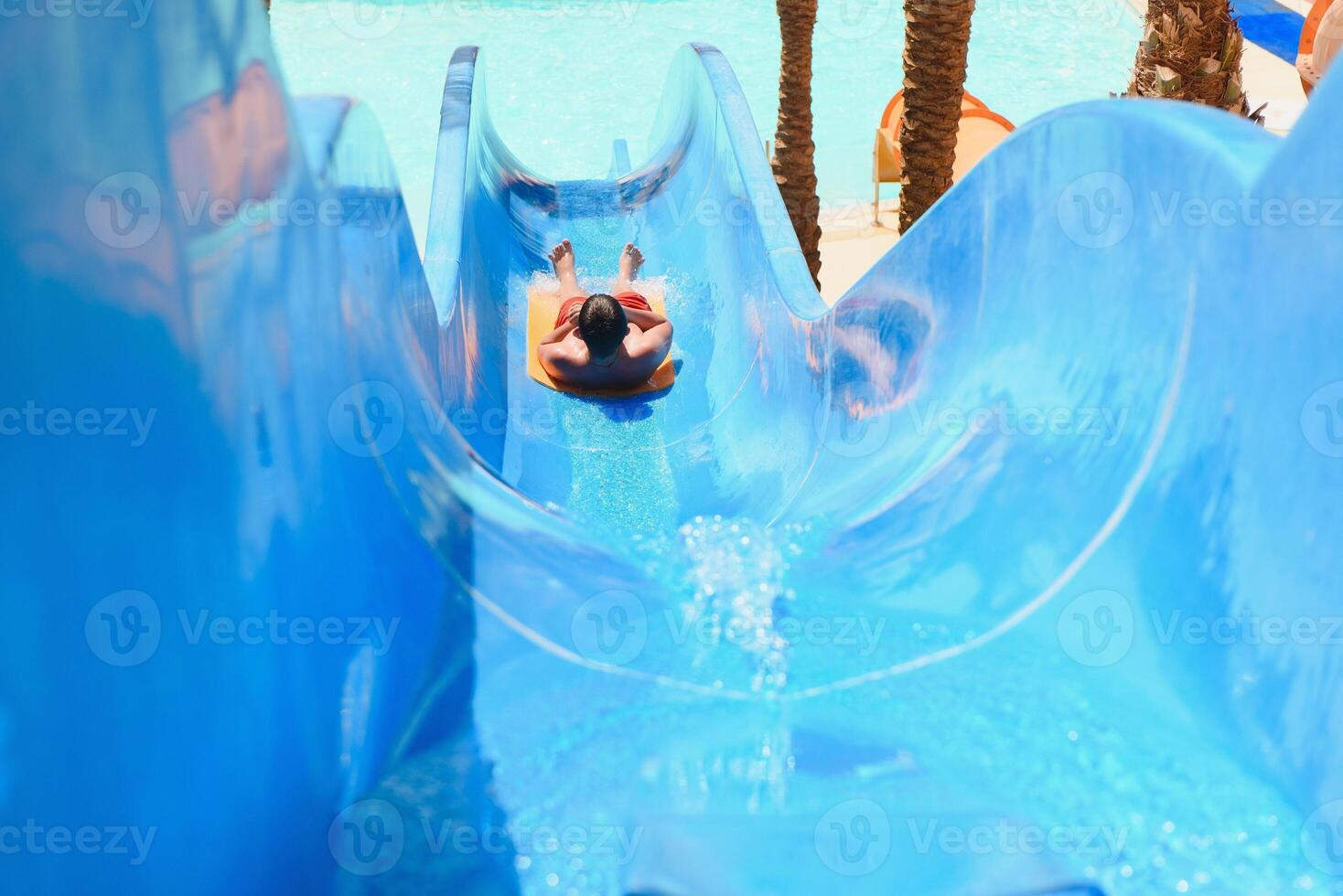 little boy sliding on the swimming pool photo