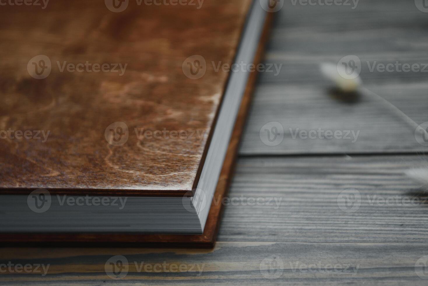 Family photo book with embossing. Photo book on a wooden background. Brown photo book with wood cover. Photoalbum with a hard cover. Wedding photo album.