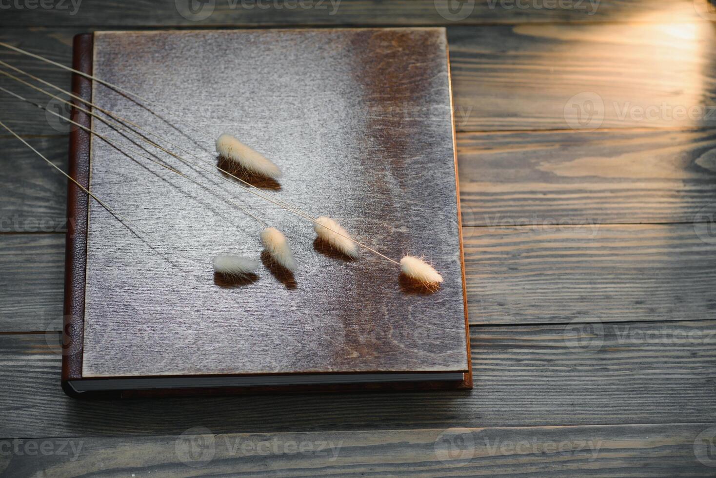 Family photo book with embossing. Photo book on a wooden background. Brown photo book with wood cover. Photoalbum with a hard cover. Wedding photo album.