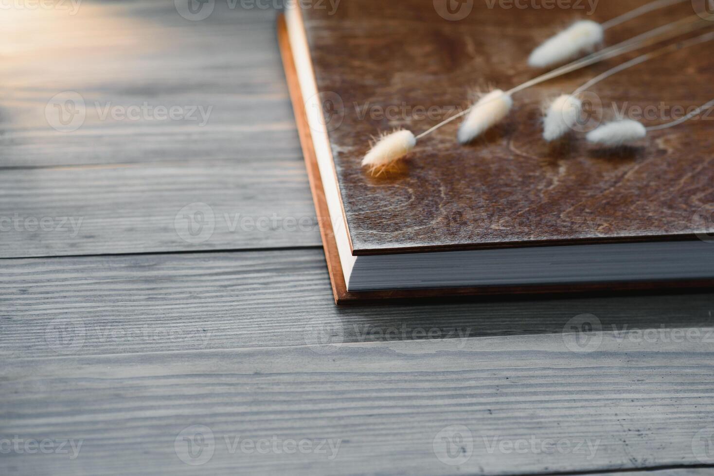 Family photo book with embossing. Photo book on a wooden background. Brown photo book with wood cover. Photoalbum with a hard cover. Wedding photo album.