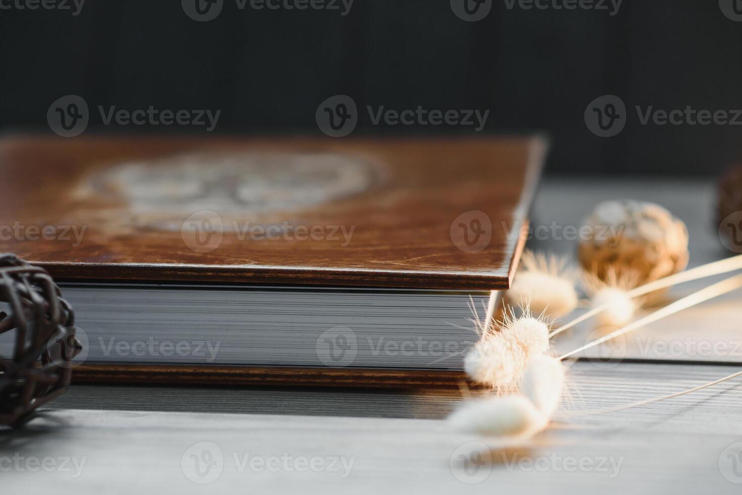 Family photo book with embossing. Photo book on a wooden background. Brown photo book with wood cover. Photoalbum with a hard cover. Wedding photo album.