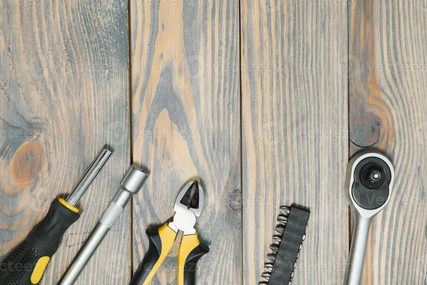 Different construction tools on a wooden background with copy space photo