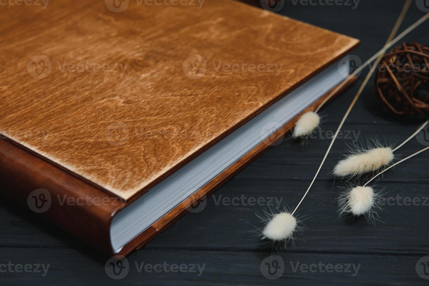 Luxury wooden photo book on natural background. Family memories photobook. Save your summer vacation memories. Photo album wedding photoalbum with wooden cover.