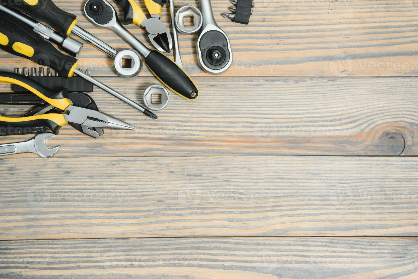 Different construction tools on a wooden background with copy space photo