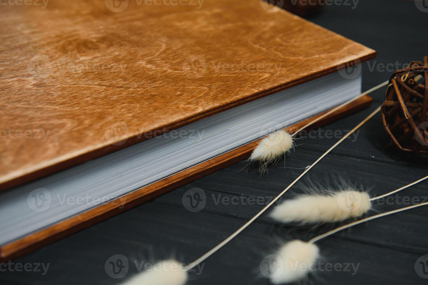 Family photo book with embossing. Photo book on a wooden background. Brown photo book with wood cover. Photoalbum with a hard cover. Wedding photo album.