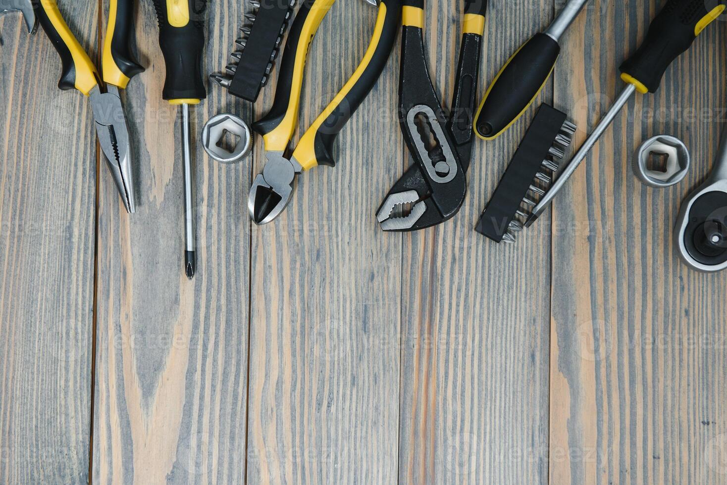Different construction tools on a wooden background with copy space photo