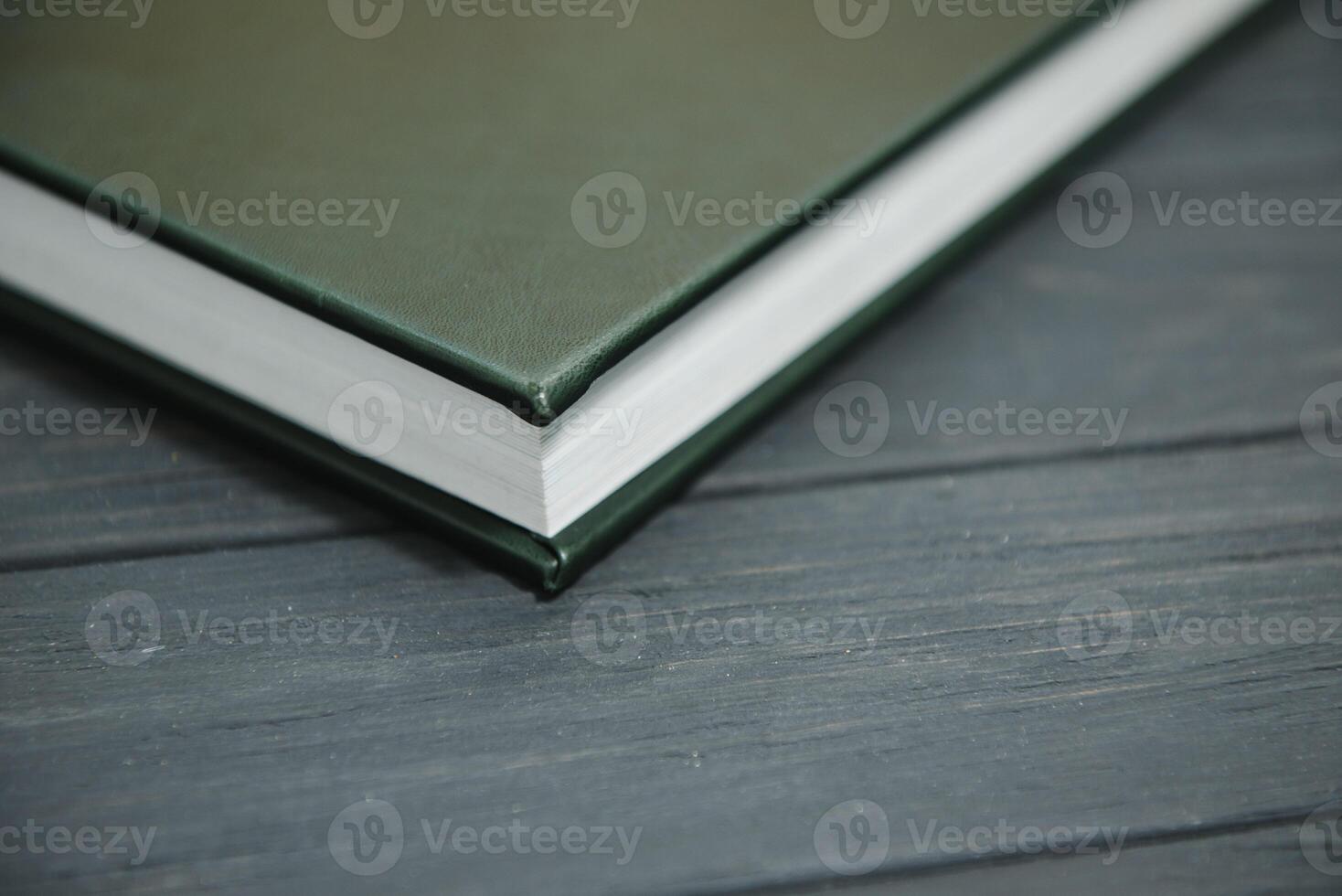 Green wedding or family photo book with leather cover. stylish wedding photo album close up. family photoalbum on wooden background.